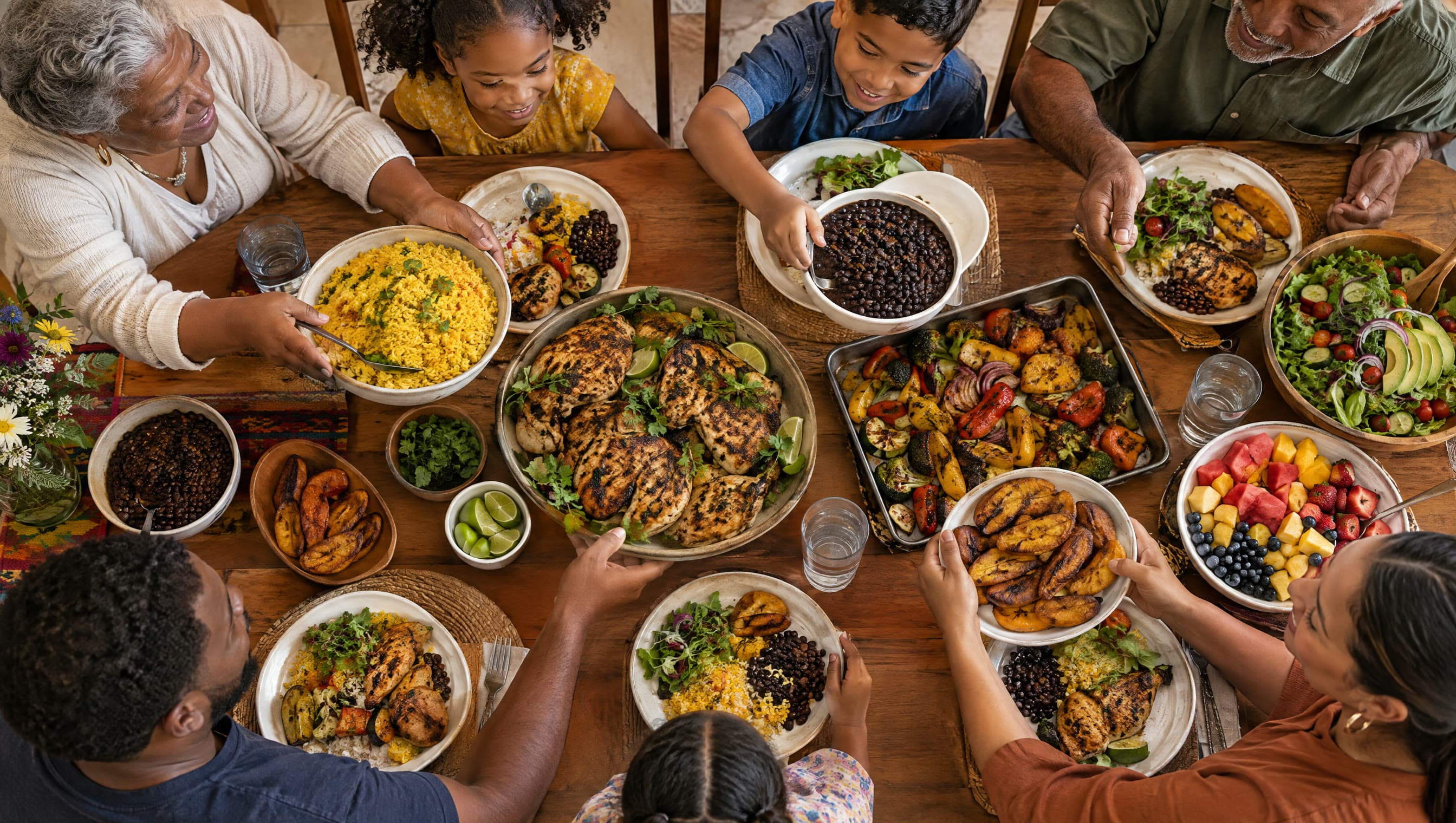 Manos de una familia pasando platos de comida casera saludable alrededor de una mesa llena